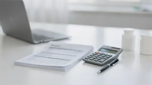 Schreibtisch mit Formularen und Hilfsmitteln zum Zuschuss für medizinische Hilfen